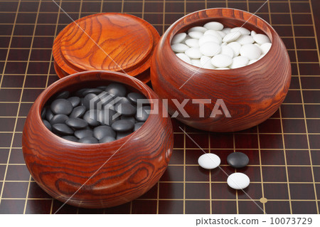 go game stones and wooden bowls on wood board 10073729