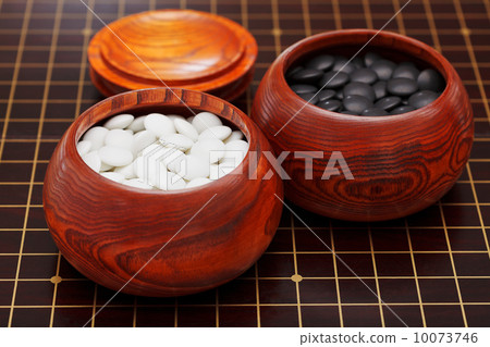 black and white go stones in wooden bowls 10073746