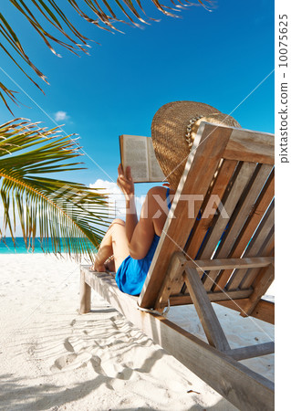 Young woman reading a book at beach 10075625