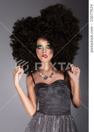 Extravagance. Eccentric Emotional Woman in Frizzy Fancy Wig with Braided Hairs Extravagance. Eccentric Emotional Woman in Frizzy Fancy Wig with Braided Hairs 10077624