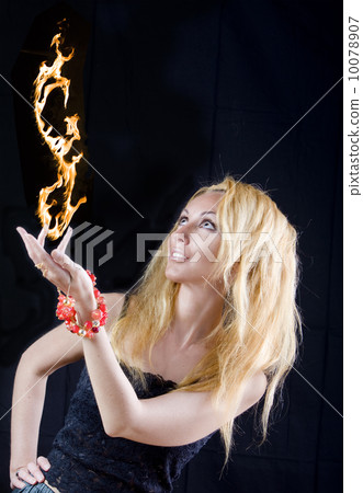 Beautiful blonde magician with fire, taking off from hand 10078907