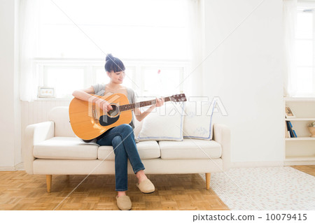 A woman playing the guitar A woman playing the guitar 10079415