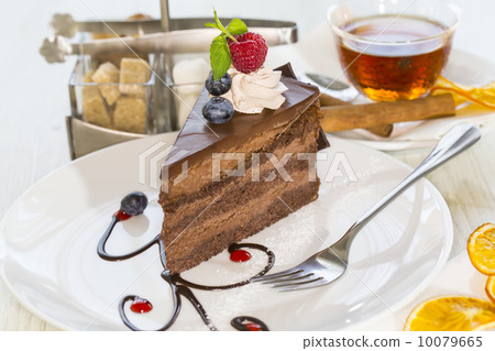 Prague piece of cake decorated with raspberries on a white background 10079665