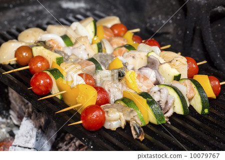 图库照片: cooking skewers of seafood in a restaurant