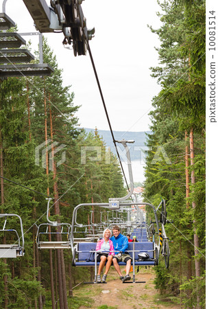 Young couple sitting on chair lift landscape 10081514