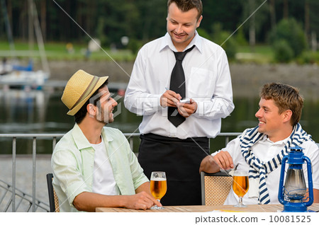 Smiling waiter taking order from men customers Smiling waiter taking order from men customers 10081525