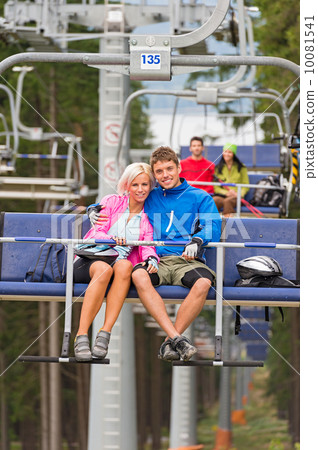 Cuddling young couple sitting on chair lift Cuddling young couple sitting on chair lift 10081541