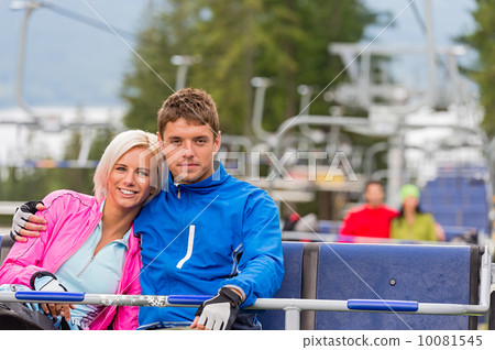 Hugging young couple sitting on chair lift Hugging young couple sitting on chair lift 10081545