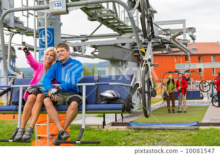 Happy couple traveling chair lift enjoying landscape 10081547