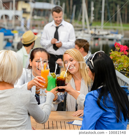Women celebrating with cocktails at restaurant 10081548