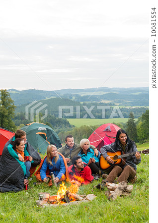 Camping friends playing guitar beside fire nature Camping friends playing guitar beside fire nature 10081554