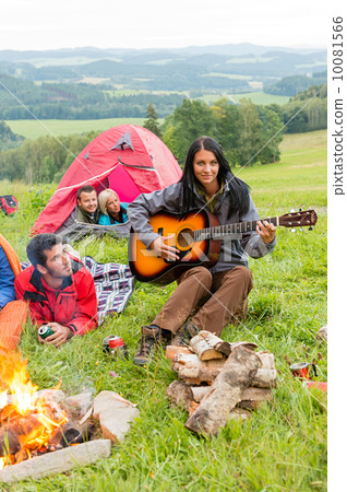 Camping friends lying tents girl playing guitar 10081566