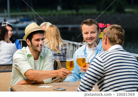 Three male friends drinking beer outdoor terrace 10081569