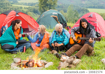 Beside campfire girls sitting listening to guitar Beside campfire girls sitting listening to guitar 10081574