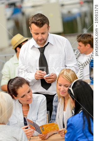 Women customers ordering from waiter at restaurant Women customers ordering from waiter at restaurant 10081578