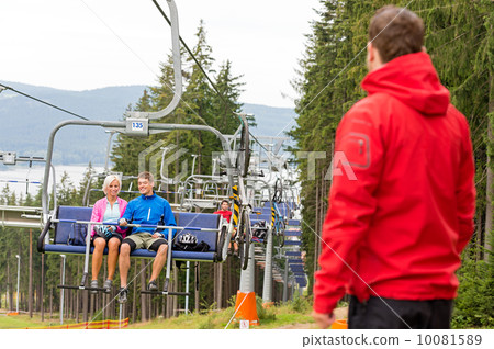 Young couple enjoying chair lift in wood Young couple enjoying chair lift in wood 10081589