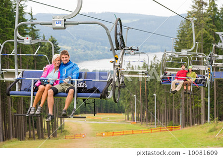 Smiling couples using chair lift scenic landscape 10081609