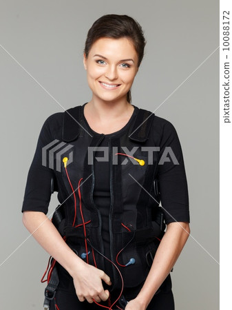Young woman putting on  Electro Muscular Stimulation EMS exercise training costume 10088172