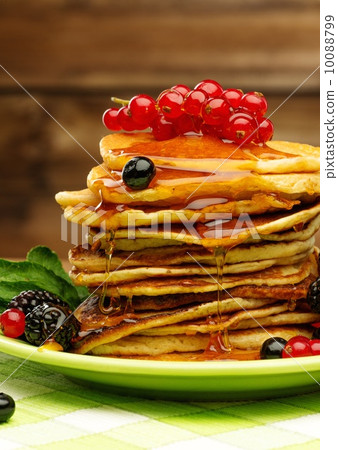 Tasty pancakes with maple syrup and fresh berries on a plate 10088799