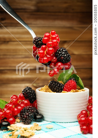 Healthy breakfast with muesli and berries on tablecloth in wooden rural interior 10088805