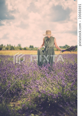 Woman in long green dress and hat in a lavender field 10088891