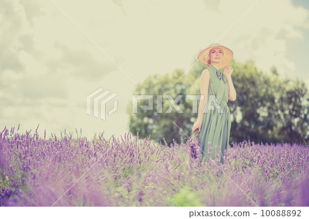 Woman in long green dress and hat in a lavender field 10088892