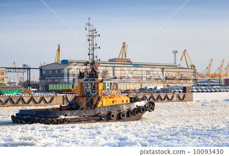 Small tug boat goes on icy channel in harbor of St.Petersburg cargo port Small tug boat goes on icy channel in harbor of St.Petersburg cargo port 10093430