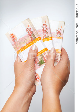 Stacks of money. Russian rubles banknotes in female hands above gray background 10093523