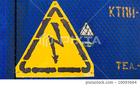 High voltage yellow sign mounted on blue metal rabitz grid with blue metal wall on background High voltage yellow sign mounted on blue metal rabitz grid with blue metal wall on background 10093664