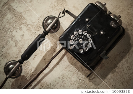 Vintage black phone hanging on old gray concrete wall 10093858