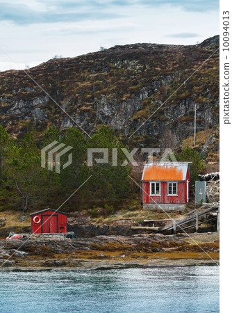 Old Norwegian red wooden houses on rocky coast 10094013