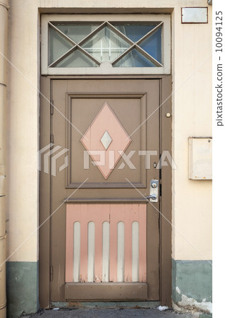 Ancient wooden door with decoration elements in old building facade. Tallinn, Estonia 10094125