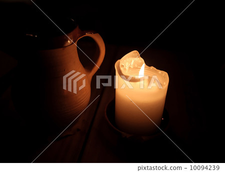Burning candle and clay cup of beer on table in old restaurant Burning candle and clay cup of beer on table in old restaurant 10094239