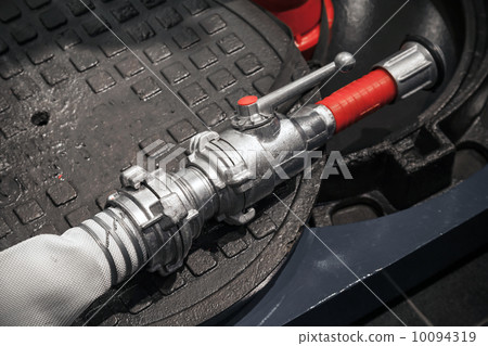 Modern metal firefighters hose on dark background Modern metal firefighters hose on dark background 10094319
