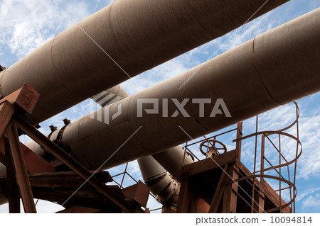 Dark industrial pipeline fragment with blue sky 10094814