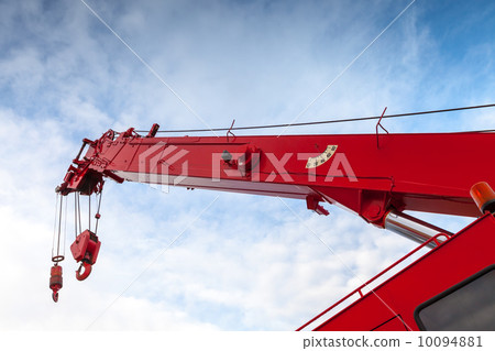 Red truck crane boom with hooks and scale weight above blue sky Red truck crane boom with hooks and scale weight above blue sky 10094881