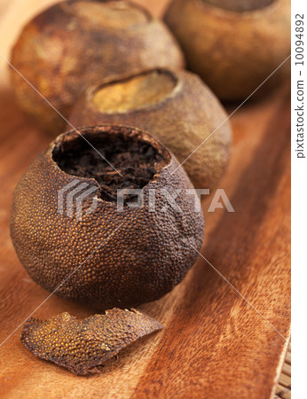 Pu-erh. Chinese tea packed in dried mandarins on wooden table Pu-erh. Chinese tea packed in dried mandarins on wooden table 10094892