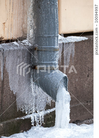 Winter city fragment. Icicles and frost on drainpipe Winter city fragment. Icicles and frost on drainpipe 10094997