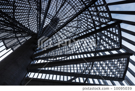 Metal modern spiral staircase details with blue sky one background 10095039