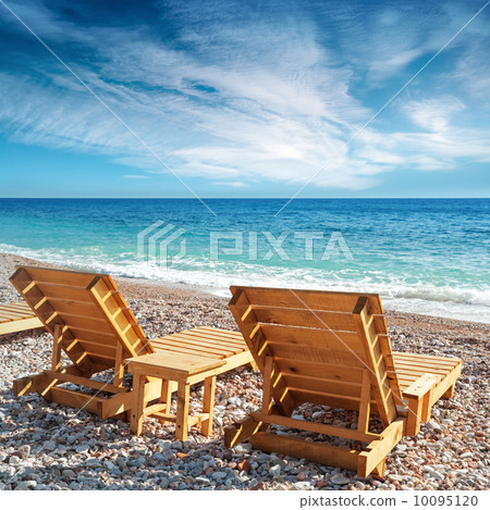 Two wooden sun loungers stand on the beach in Montenegro Two wooden sun loungers stand on the beach in Montenegro 10095120