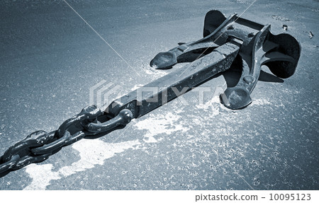 Mooring anchor with chain on dry ground. Monochrome photo Mooring anchor with chain on dry ground. Monochrome photo 10095123