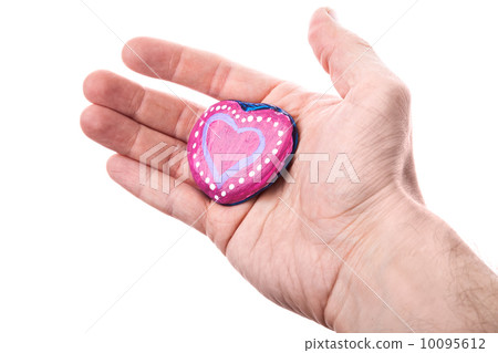 Handmade pink painted heart shaped stone as a gift in man's hand isolated on white Handmade pink painted heart shaped stone as a gift in man's hand isolated on white 10095612