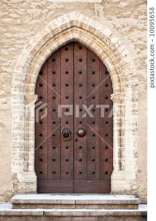 Ancient dark wooden door in old building facade. Tallinn, Estonia Ancient dark wooden door in old building facade. Tallinn, Estonia 10095658