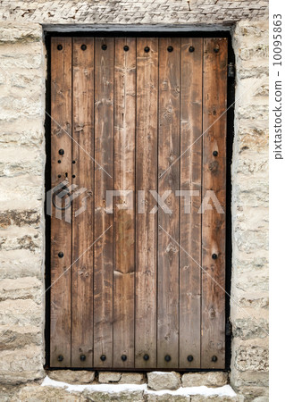 Ancient wooden door in old stone castle wall. Tallinn, Estonia 10095863