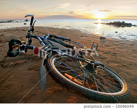 Bicycle lying on the beach 10096049