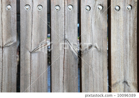 Weathered boards and bolts of wooden fence 10096389