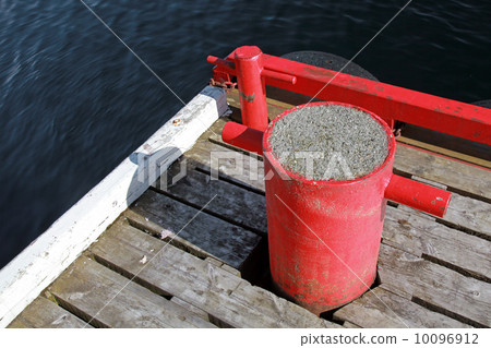 Red mooring bollards on wooden pier 10096912
