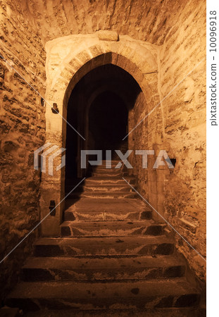 Old Tallinn street fragment with gate in stone wall at night 10096918