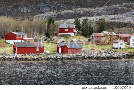 Traditional Norwegian small village with red wooden houses on rocky coast in spring 10097049