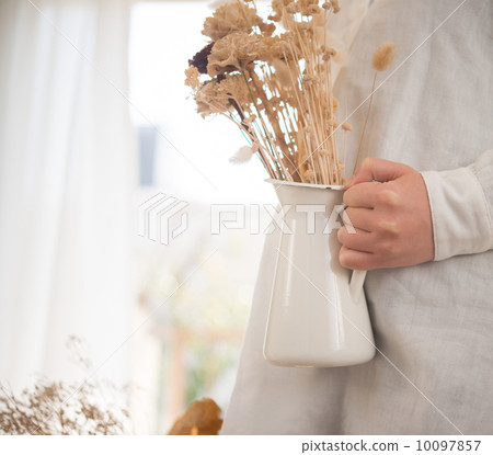 一位女士正在花瓶裡插乾花。 一位女士正在花瓶裡插乾花。 10097857